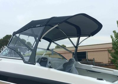 Bimini top duckbill extension in a boat, front clear side curtain installed, in North Bank